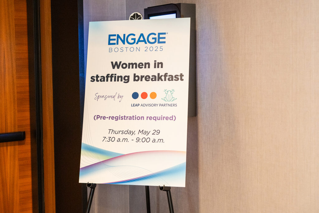 A sign near a doorway reads: ENGAGE Boston 2025 Women in Staffing Breakfast. Sponsored by Leap Advisory Partners and Bullhorn. (Pre-registration required) Thursday, May 29, 7:30–9:00 a.m. Perfect for those interested in corporate videography.